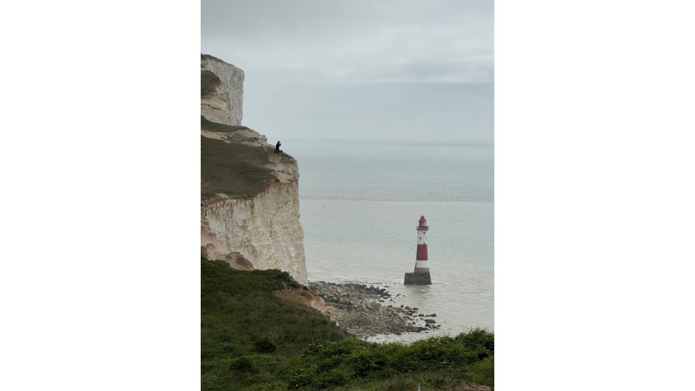 Woman admiring a lighthouse in the ocean