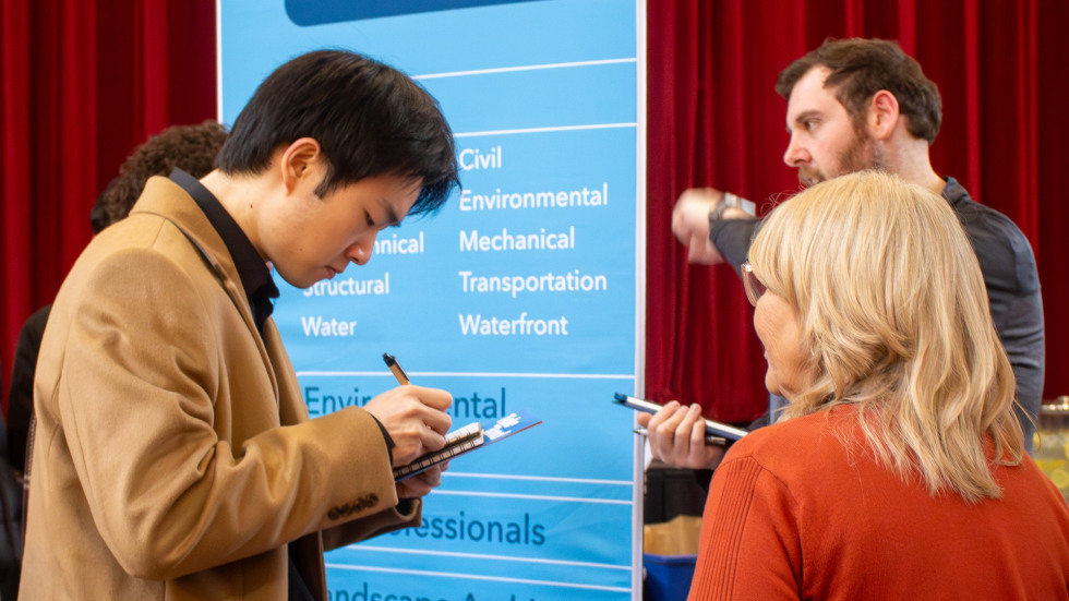 student writes their name on an employer's list