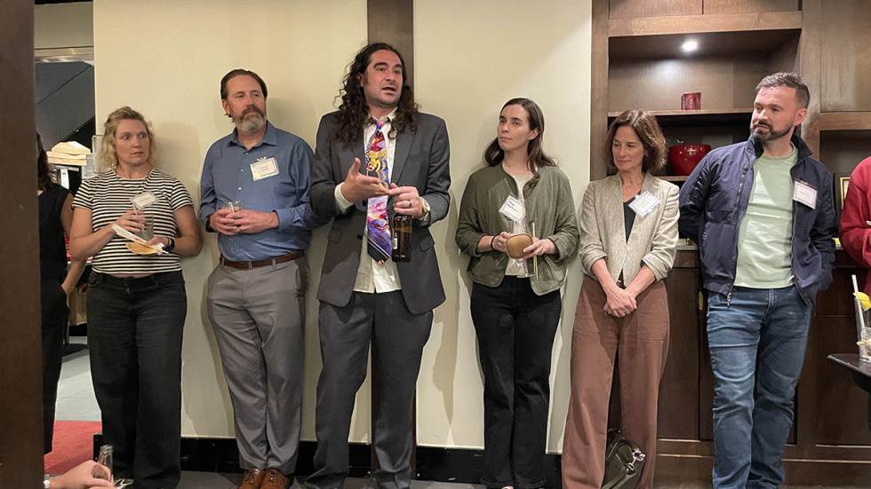man speaking to room of people at event